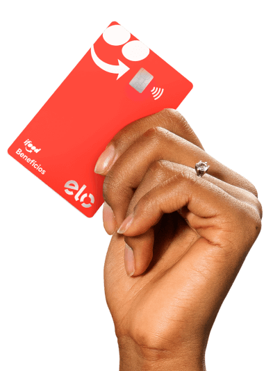 Mão de uma pessoa segurando o cartão do iFood Benefícios